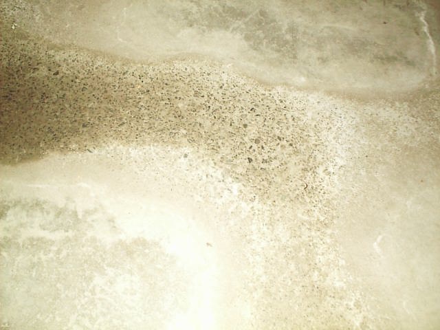 Etching of concrete where acidic runoff has flowed across a concrete floor.